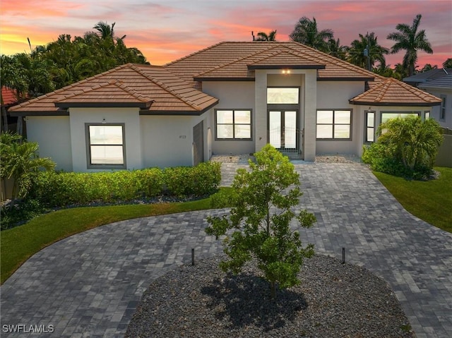 front of property at dusk featuring stucco siding