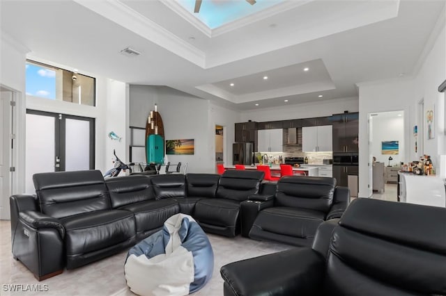 living room featuring light tile patterned flooring, ceiling fan, a raised ceiling, crown molding, and french doors