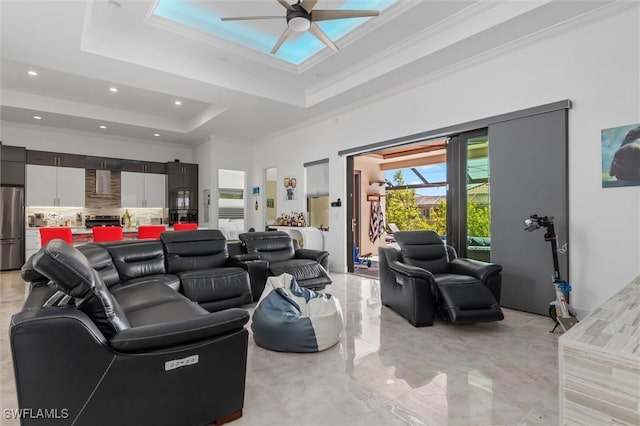 living room with crown molding, ceiling fan, and a tray ceiling