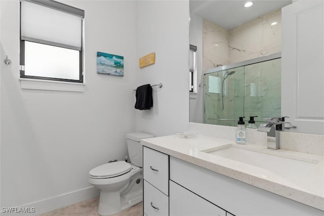 bathroom featuring a shower with door, vanity, and toilet