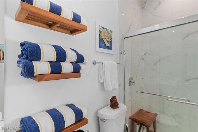 bathroom featuring an enclosed shower and toilet