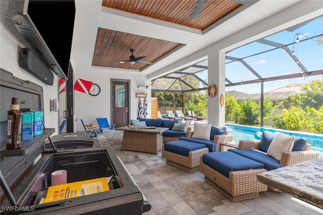 view of patio with an outdoor living space, a lanai, and ceiling fan