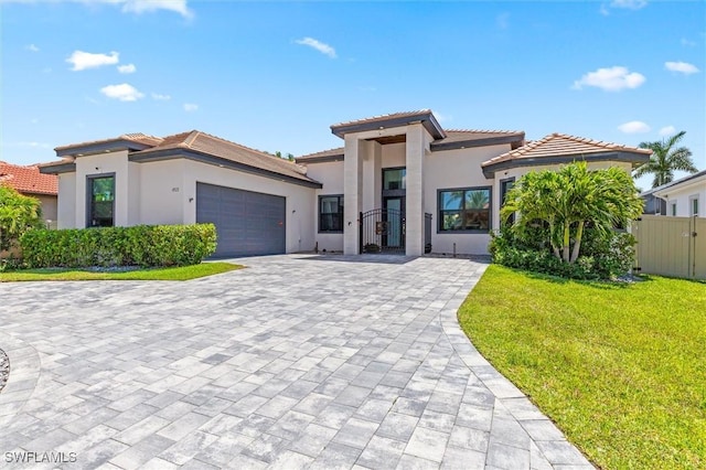 view of front of house featuring a garage and a front lawn