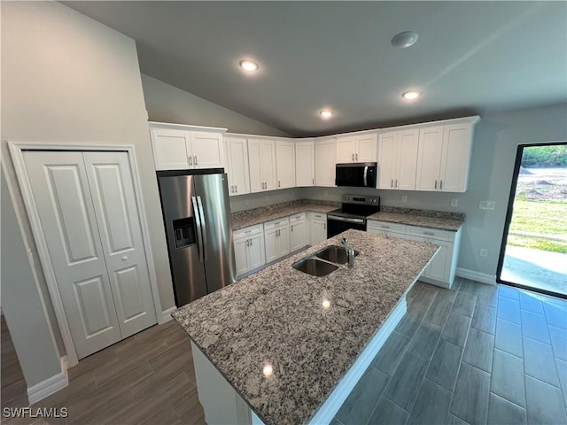 kitchen with a sink, appliances with stainless steel finishes, white cabinets, and vaulted ceiling