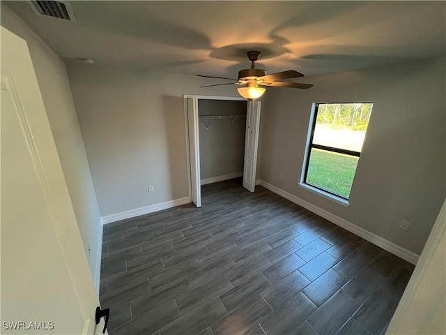 unfurnished bedroom with a ceiling fan, baseboards, visible vents, wood tiled floor, and a closet