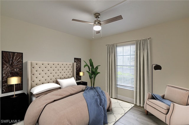 bedroom with ceiling fan, baseboards, and wood finished floors