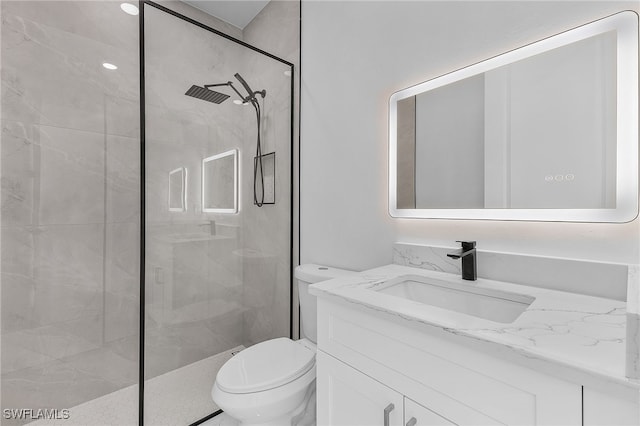 bathroom featuring vanity, toilet, and tiled shower