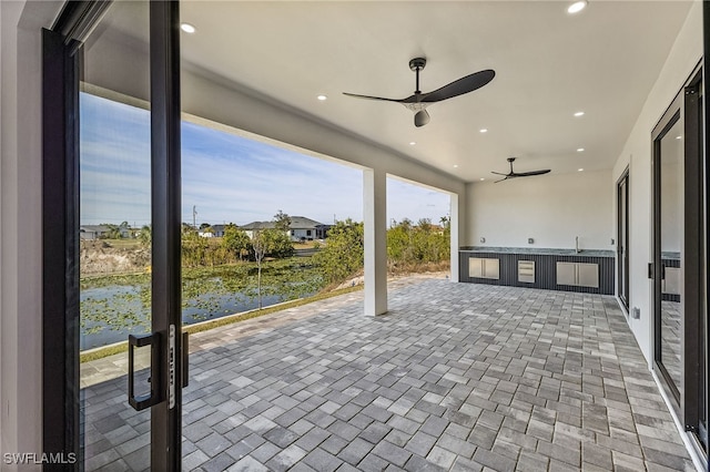 view of patio / terrace with a water view and ceiling fan