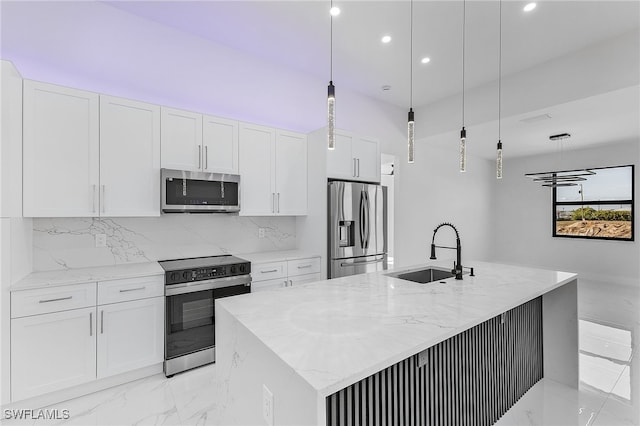 kitchen featuring sink, white cabinets, hanging light fixtures, a kitchen island with sink, and stainless steel appliances