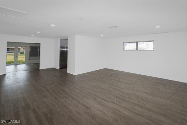 spare room featuring dark wood-type flooring and a wealth of natural light