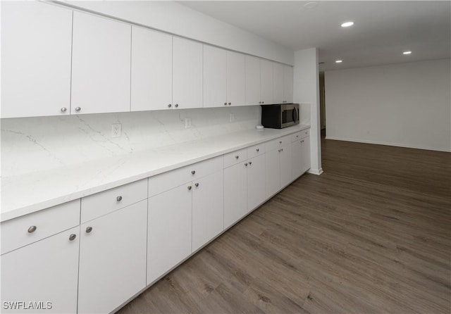 kitchen featuring dark hardwood / wood-style flooring, decorative backsplash, and white cabinets