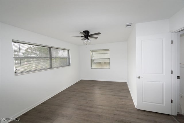 empty room with dark hardwood / wood-style floors and ceiling fan