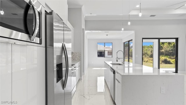 kitchen featuring marble finish floor, modern cabinets, appliances with stainless steel finishes, and a sink