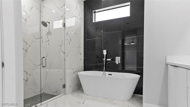 full bath with marble finish floor, a marble finish shower, vanity, and a soaking tub