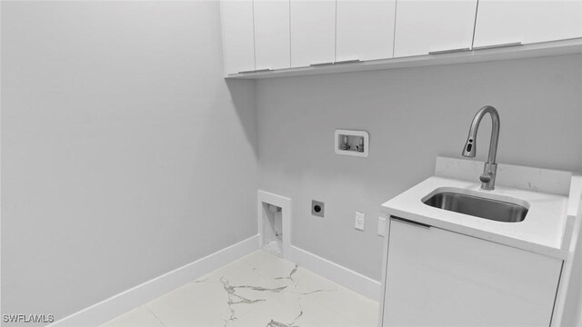 clothes washing area with hookup for a washing machine, cabinet space, hookup for an electric dryer, a sink, and baseboards