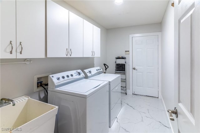 clothes washing area with sink, cabinets, and washing machine and clothes dryer