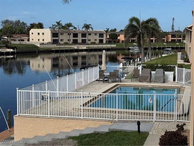 view of swimming pool featuring a patio and a water view