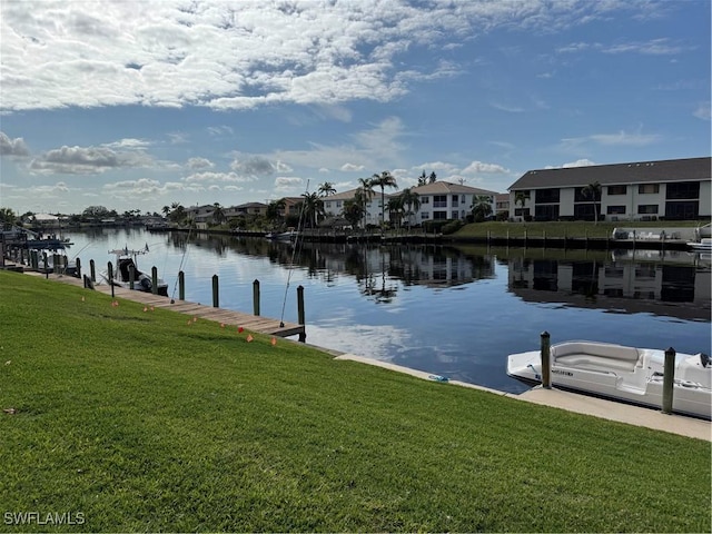 dock area with a water view and a yard