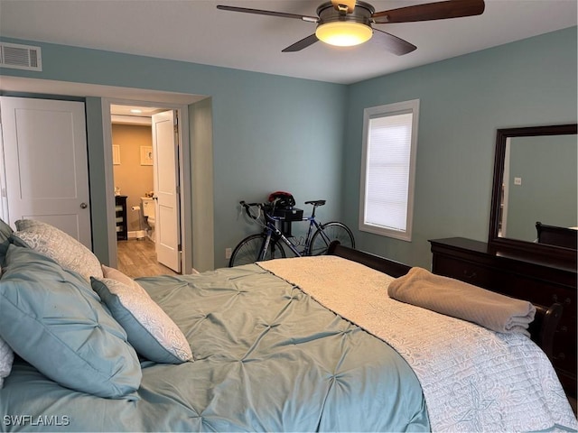 bedroom with ceiling fan, ensuite bathroom, and light hardwood / wood-style floors