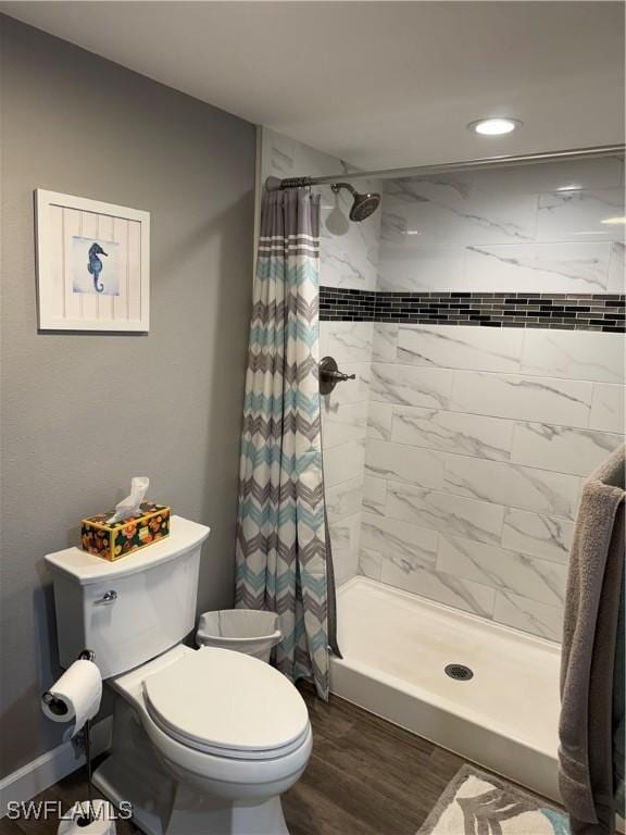 bathroom with a shower with curtain, toilet, and hardwood / wood-style flooring