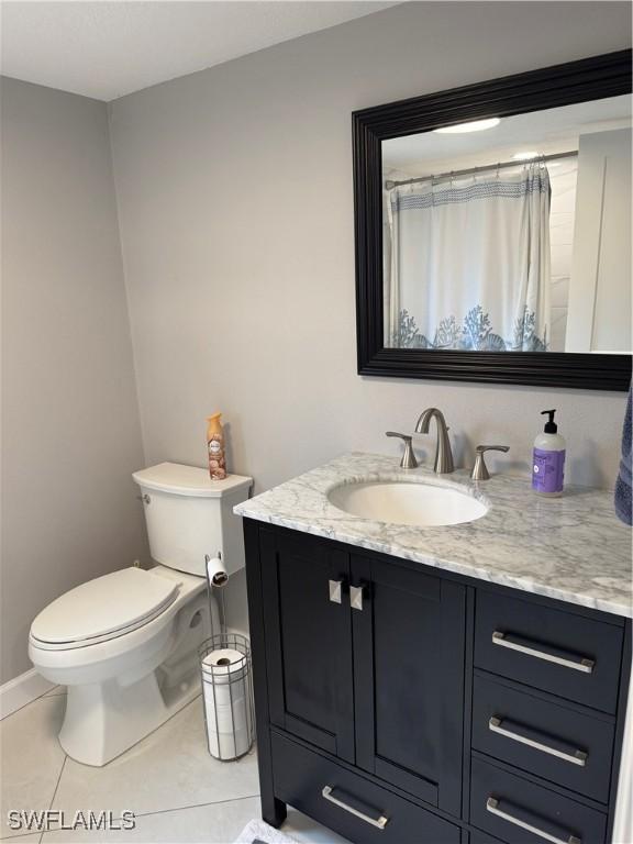 bathroom with tile patterned flooring, vanity, a shower with shower curtain, and toilet