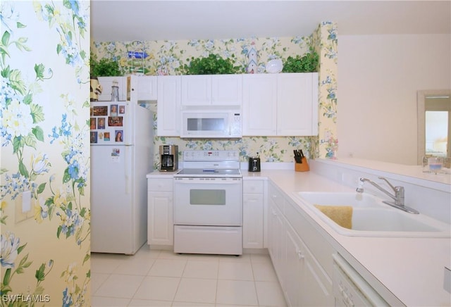 kitchen with white cabinetry, sink, light tile patterned floors, and white appliances