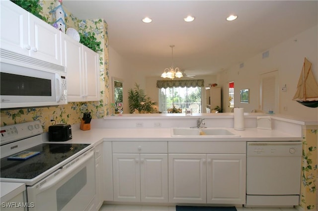 kitchen with white cabinetry, sink, white appliances, and kitchen peninsula