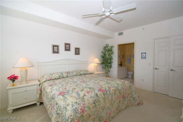 bedroom with ceiling fan, connected bathroom, and light carpet