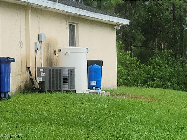 view of property exterior with a lawn and central air condition unit