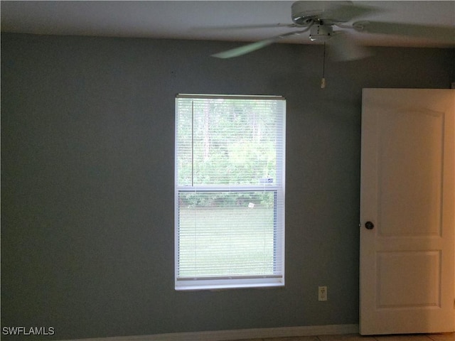 spare room featuring ceiling fan and plenty of natural light