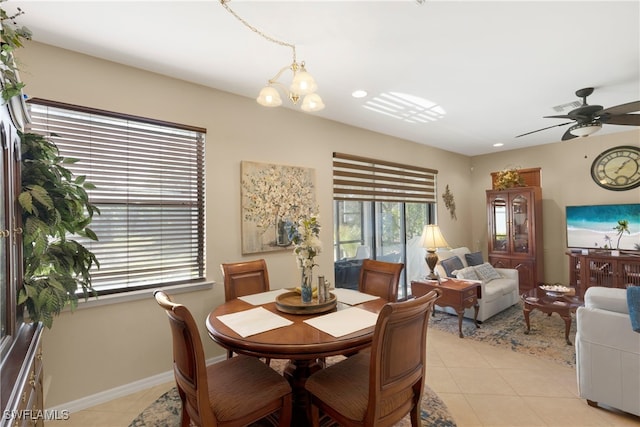 dining room featuring ceiling fan with notable chandelier and light tile patterned floors