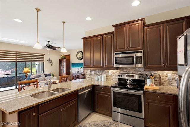 kitchen featuring sink, tasteful backsplash, kitchen peninsula, pendant lighting, and stainless steel appliances