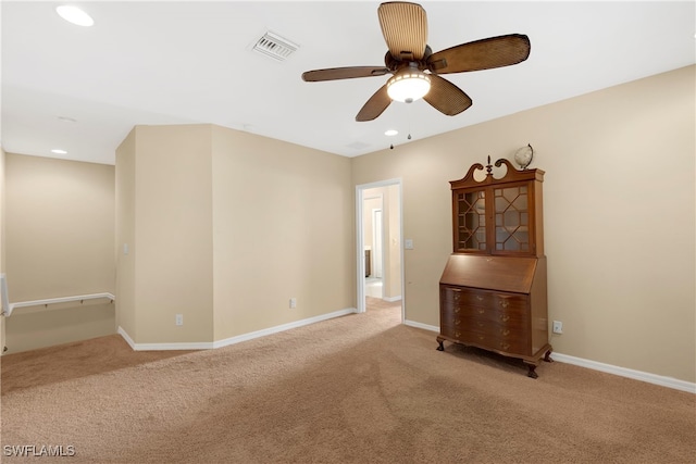 spare room with light colored carpet and ceiling fan