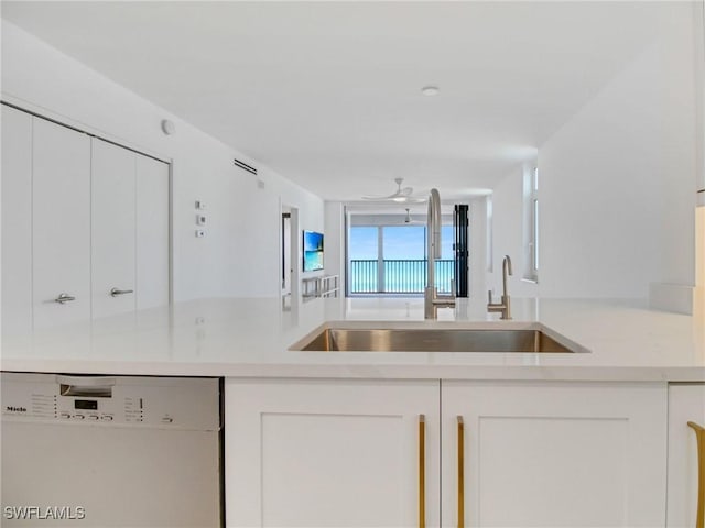 kitchen featuring sink, white cabinets, and white dishwasher