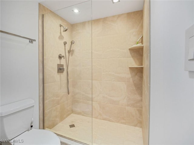 bathroom with toilet and a tile shower