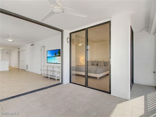 empty room with ceiling fan and a wall of windows