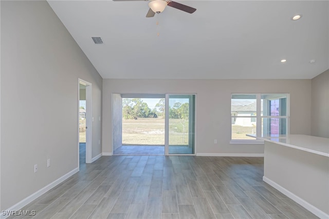 unfurnished living room featuring lofted ceiling, plenty of natural light, and light hardwood / wood-style floors