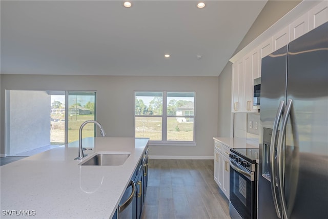 kitchen with light stone counters, sink, white cabinets, and appliances with stainless steel finishes