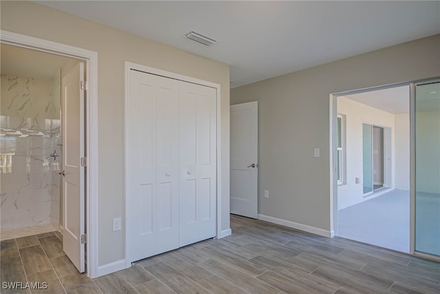 unfurnished bedroom featuring ensuite bathroom and a closet