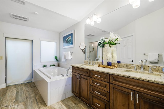 bathroom with vanity, shower with separate bathtub, and hardwood / wood-style floors