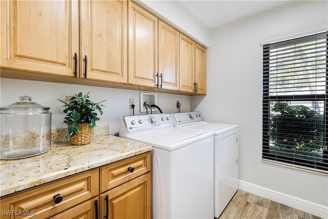 washroom featuring cabinets, independent washer and dryer, and light hardwood / wood-style floors