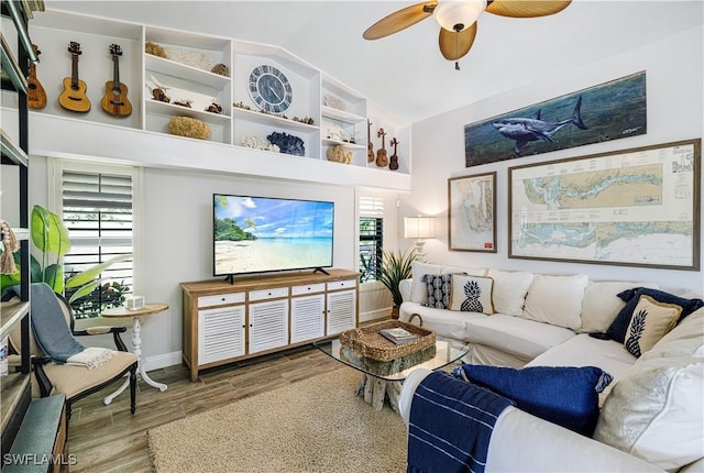 living room featuring lofted ceiling, ceiling fan, wood-type flooring, and a healthy amount of sunlight