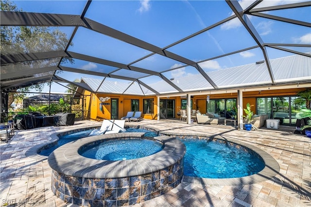 view of swimming pool featuring an in ground hot tub, a lanai, and a patio area