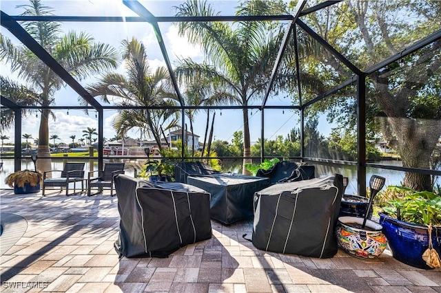 view of patio with a water view and a lanai