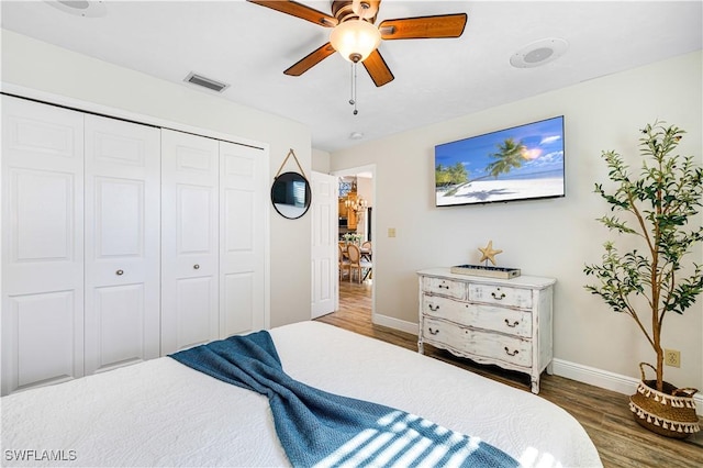 bedroom featuring a closet, dark hardwood / wood-style floors, and ceiling fan