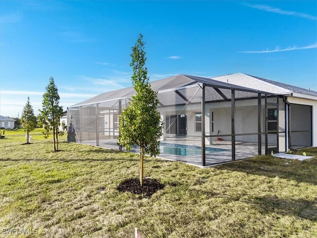 rear view of property featuring a yard, a lanai, and a patio