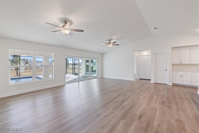 unfurnished living room with lofted ceiling, ceiling fan, and light wood-type flooring