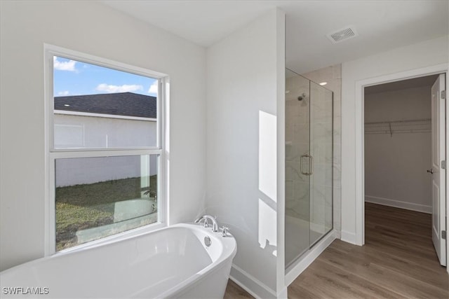 bathroom with separate shower and tub and hardwood / wood-style floors