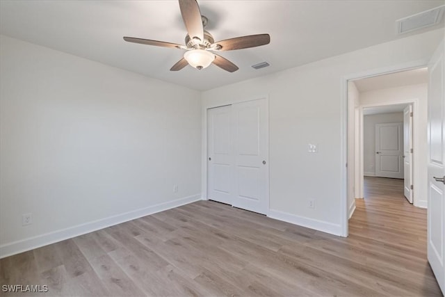 unfurnished bedroom featuring ceiling fan, light hardwood / wood-style floors, and a closet