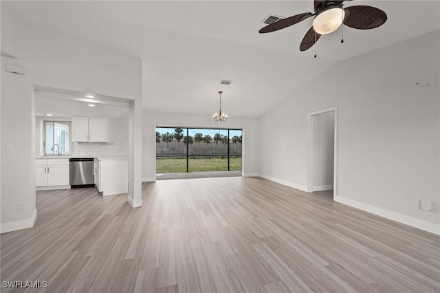 unfurnished living room featuring sink, ceiling fan with notable chandelier, vaulted ceiling, and light hardwood / wood-style floors